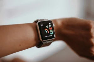 Сравнение Apple Watch Ultra 3 и Apple Watch Ultra 2 на фоне дисплея и корпуса, показывающее отличия дизайна и функций